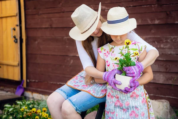 Jardinage, plantation - mère avec sa fille plantant des fleurs dans le pot de fleurs — Photo