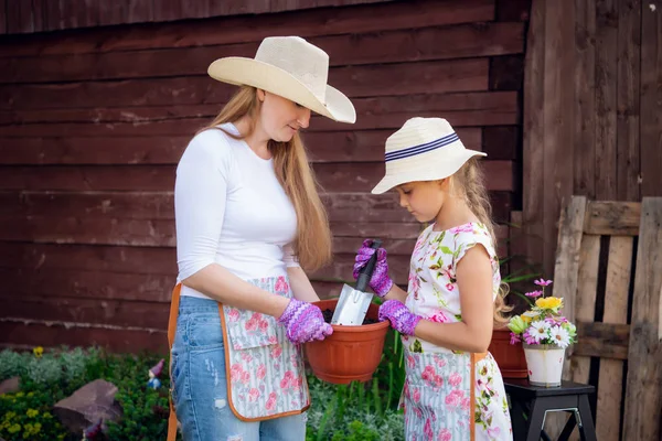 Jardinage, plantation - mère avec sa fille plantant des fleurs dans le pot de fleurs — Photo