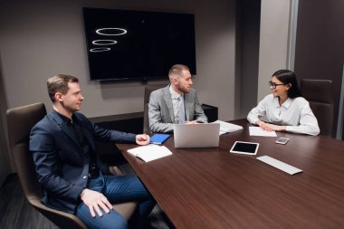 Başlangıç iş, farklı yaş ve ırklar yaratıcı iş adamları karanlık modern ofis iç toplantı odasında toplamak, canlı tartışıyor