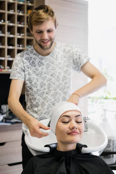 Женщина, получающая лечение волос в спа-салоне с использованием шампуня для волос, салона красоты, мойки волос — стоковое фото