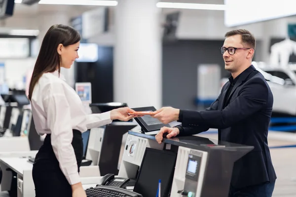 Vriendelijke vrouw personeel het nemen van paspoort van passagier op de luchthaven check-in balie — Stockfoto