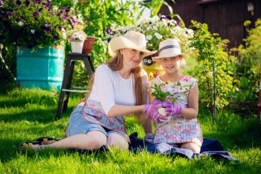 Anne ve kızı bahçede birlikte çalışıyorlar.