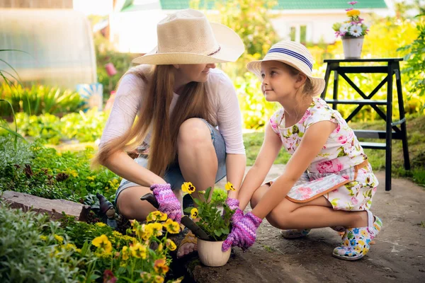 Jardinage, plantation - mère avec sa fille plantant des fleurs dans le pot de fleurs — Photo