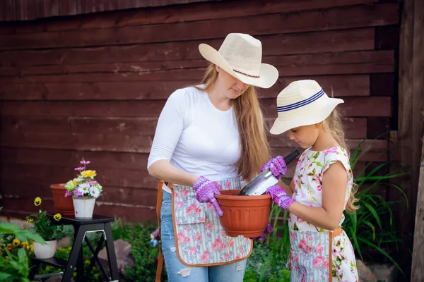 Jardinage, plantation - mère avec sa fille plantant des fleurs dans le pot de fleurs — Photo