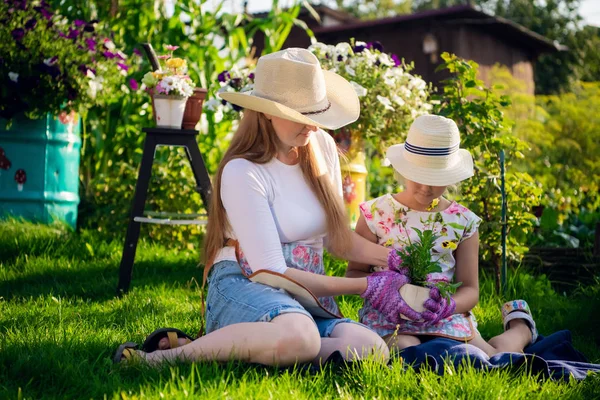 Jardinage, plantation - mère avec sa fille plantant des fleurs dans le pot de fleurs — Photo