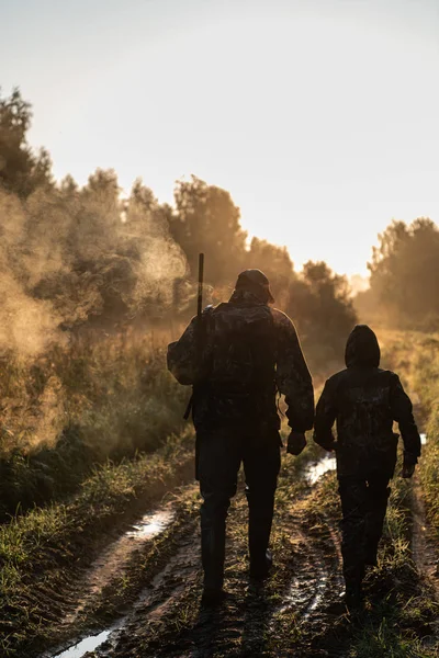 Caza de verano al amanecer. Hunter moviéndose con escopeta y buscando presas . — Foto de Stock