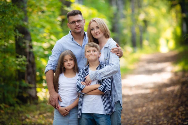 Gelukkige familie buiten tijd doorbrengen met elkaar. Vader, moeder, dochter en zoon vermaken zich in een zomerpark in de zomer — Stockfoto