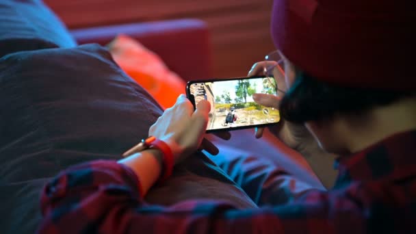 俄罗斯莫斯科- 2019年12月6日：女孩手持智能手机iphone 11 Pro玩在线手机游戏Pubg，一款著名的儿童和青少年在线射击游戏 — 图库视频影像
