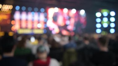 Esports etkinliği arka planı bulanıklaştırdı. Ana sahne, şimşek, aydınlatma, büyük ekranda oyun anları ve tribünlerdeki hayranlar..