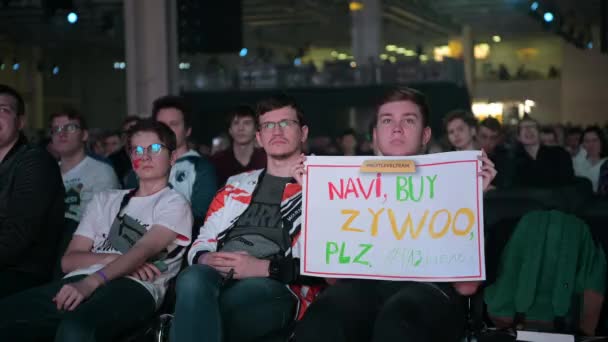 MOSCOU - 23 DÉCEMBRE 2019 : manifestation e-sport. Heureux fan dévoué à l'aréna. Acclamation avec une affiche faite par soi-même avec les mains levées . — Video