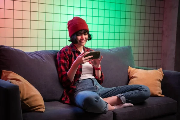 ผู้หญิงวัยรุ่นถือสมาร์ทโฟนในขณะที่เล่นเกมยิงออนไลน์ . — ภาพถ่ายสต็อก