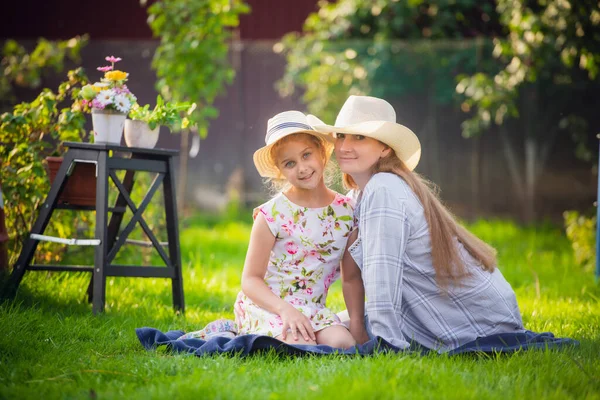 Bonne mère et fille dans le parc. Beauté scène de nature avec style de vie familial en plein air. Heureuse famille reposant ensemble sur l'herbe verte, s'amusant en plein air. Bonheur et harmonie dans la vie familiale — Photo