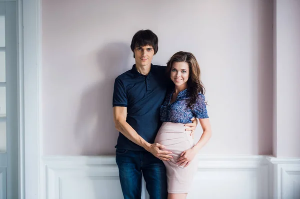 Šťastný člověk je láskyplně drží jeho těhotná manželka břicho. — Stock fotografie