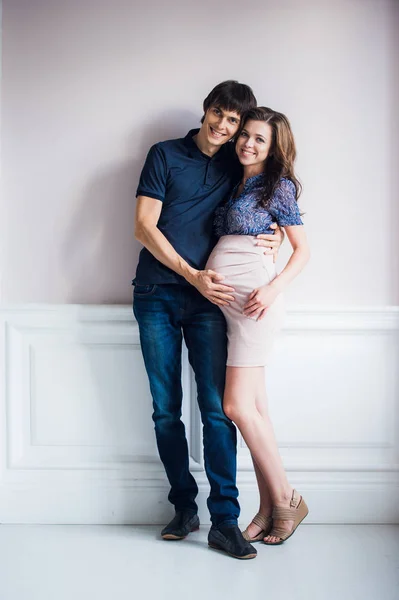 Bella coppia, giovane donna incinta e uomo che si abbraccia con amore a casa — Foto Stock
