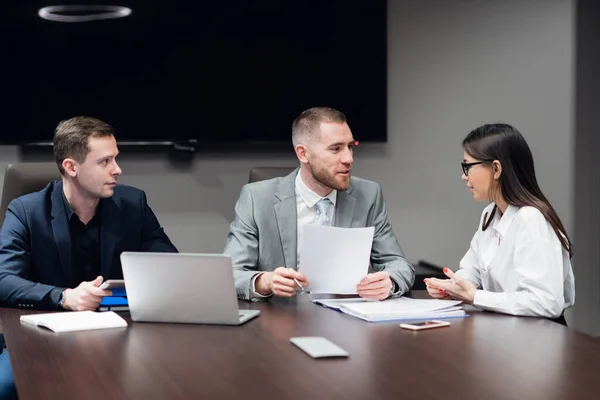 Retrato de três colegas de trabalho discutindo plano de negócios no escritório — Fotografia de Stock