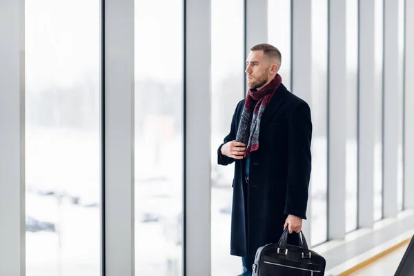 Бизнесмен сидит в аэропорту в ожидании рейса. Мужчина в бизнес-зале аэропорта сидит в зале ожидания. — стоковое фото