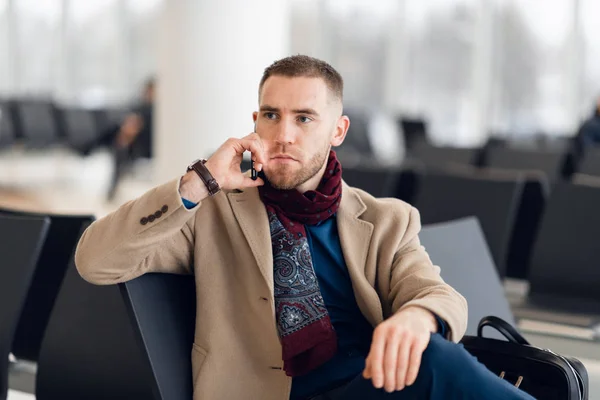 Businessman sitting at airport waiting lounge and waiting for flight. Male executive in airport business lounge sitting at waiting area. — Stock Photo, Image