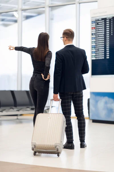 Üzletemberek formális ruházati séta kerekes táskák a repülőtér terminál — Stock Fotó