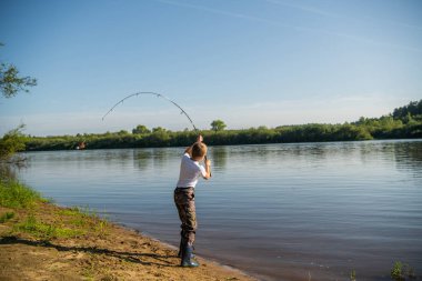 Bir yaz günü açık havada balık tutan bir çocuğun fotoğrafı..