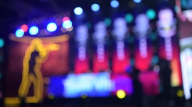 Esport olayının bulanık arkaplanı. Ana sahne, şimşek, aydınlatma, oyun anları olan büyük ekranlar. Sahnedeki oyuncular.