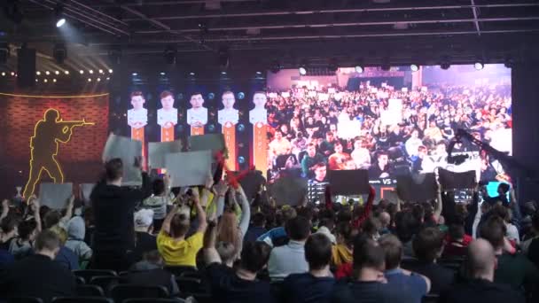 MOSCOW - DECEMBER 23 2019: esports gaming event. Main venue, lots fans with posters watching the game and supporting favorite teams. Big crowd at arena. — Stok video
