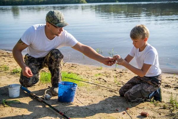 Lagarbete. Far och son fiskar en sommarhelg. Hobby- och sportaktiviteter, beredning av fiskbete. — Stockfoto