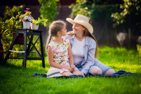 Jeune jolie femme avec fille mignonne dans le jardin à l'été souriant heureux, style de vie gens concept — Photo