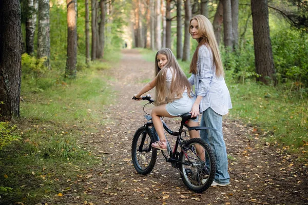 Mère emmenant son enfant faire un tour à vélo. Aide pour une première balade à vélo . — Photo