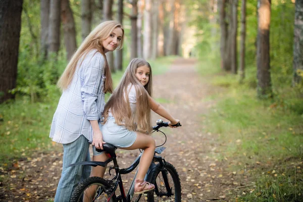 Mère emmenant son enfant faire un tour à vélo. Aide pour une première balade à vélo . — Photo