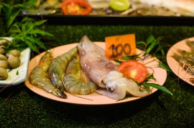 Tayland 'daki gece pazarında taze çiğ mürekkep balığı ve karides..