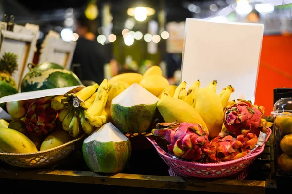 Tropiska thai frukter stall på lokala matmarknaden i Thailand. Kokosnöt, drakfrukt, banan och mango på natten rättvis. — Stockfoto