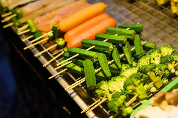 Broccoli e carote su spiedini per barbecue al mercato alimentare in Thailandia. Cibo asiatico popolare. Foto scattata in condizioni di scarsa illuminazione notturna — Foto Stock