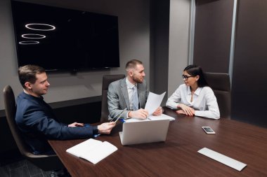 İş arkadaşları konferans odasında toplanıp projeyi tartışacaklar.