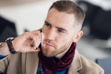 İş adamı havaalanında oturuyor, bekleme salonunda ve uçuşu bekliyor. Havaalanı işletme bölümünde erkek yönetici bekleme salonunda oturuyor..