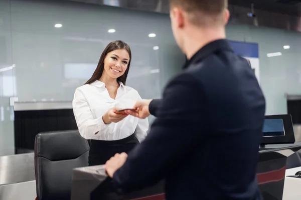 Knappe zakenman overhandigt vliegticket bij check-in balie — Stockfoto