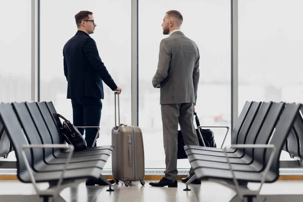 Business colleagues waiting at airport lounge standing and talking — Stock Photo, Image