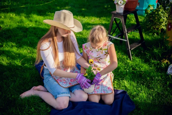 Deux personnes - mère et fille - plantent des fleurs dans le pot pour décorer le jardin — Photo