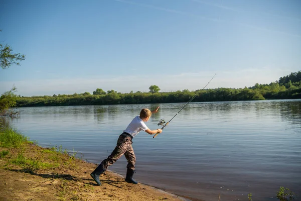 Foto van een jonge jongen die buiten vist op een zomerdag. — Stockfoto