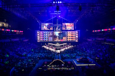 Esport etkinliğinin bulanık arkaplanı - ana sahne mekanı, büyük ekran ve turnuva başlamadan önce ışıklar.
