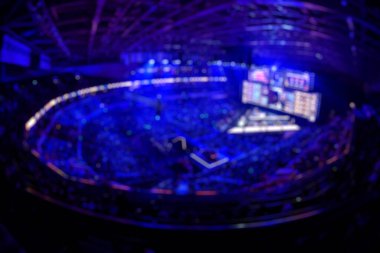 Esport etkinliğinin bulanık arkaplanı - ana sahne mekanı, büyük ekran ve turnuva başlamadan önce ışıklar.