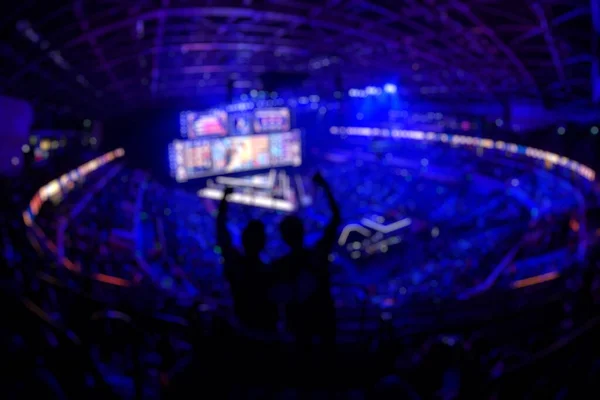 Suddig bakgrund av en esports händelse - Fläkt på en tribun på turneringar arena med händerna upp. — Stockfoto