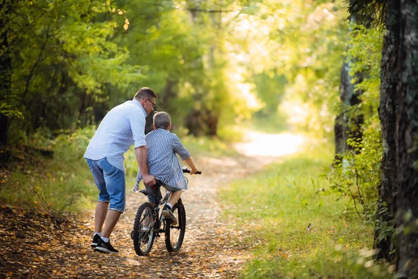 Père enseigne à son fils à faire du vélo à la campagne — Photo