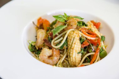 Spagetti deniz ürünleri fesleğen ve bitki ile karıştırın