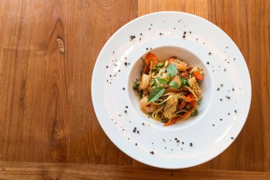 Spagetti deniz ürünleri fesleğen ve bitki ile karıştırın