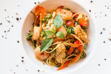 Spagetti deniz ürünleri fesleğen ve bitki ile karıştırın