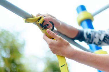 TRX açık hava eğitimi için hazırlanan genç bir kadın. ,