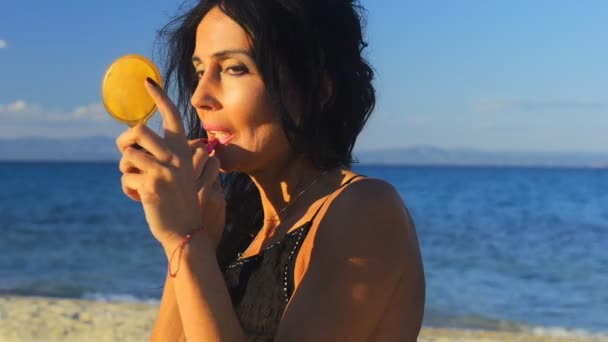 Young Brunette Woman Beach Holds Little Mirror Lipstick Lipstick Large — Stock Video