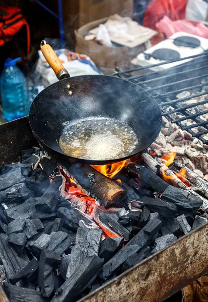 Old chinese wok pan with boiling oil on a fire — Stock Photo, Image