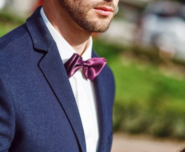 Lüks beyaz gömlek ve mavi ceket ve papyon ile sakallı yakışıklı delikanlı