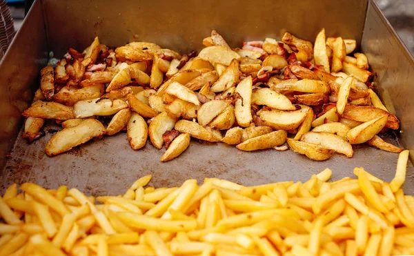 Steel container with roasted potato wedges, french fries